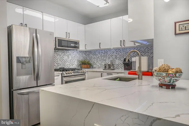 a kitchen with stainless steel appliances a refrigerator sink and stove