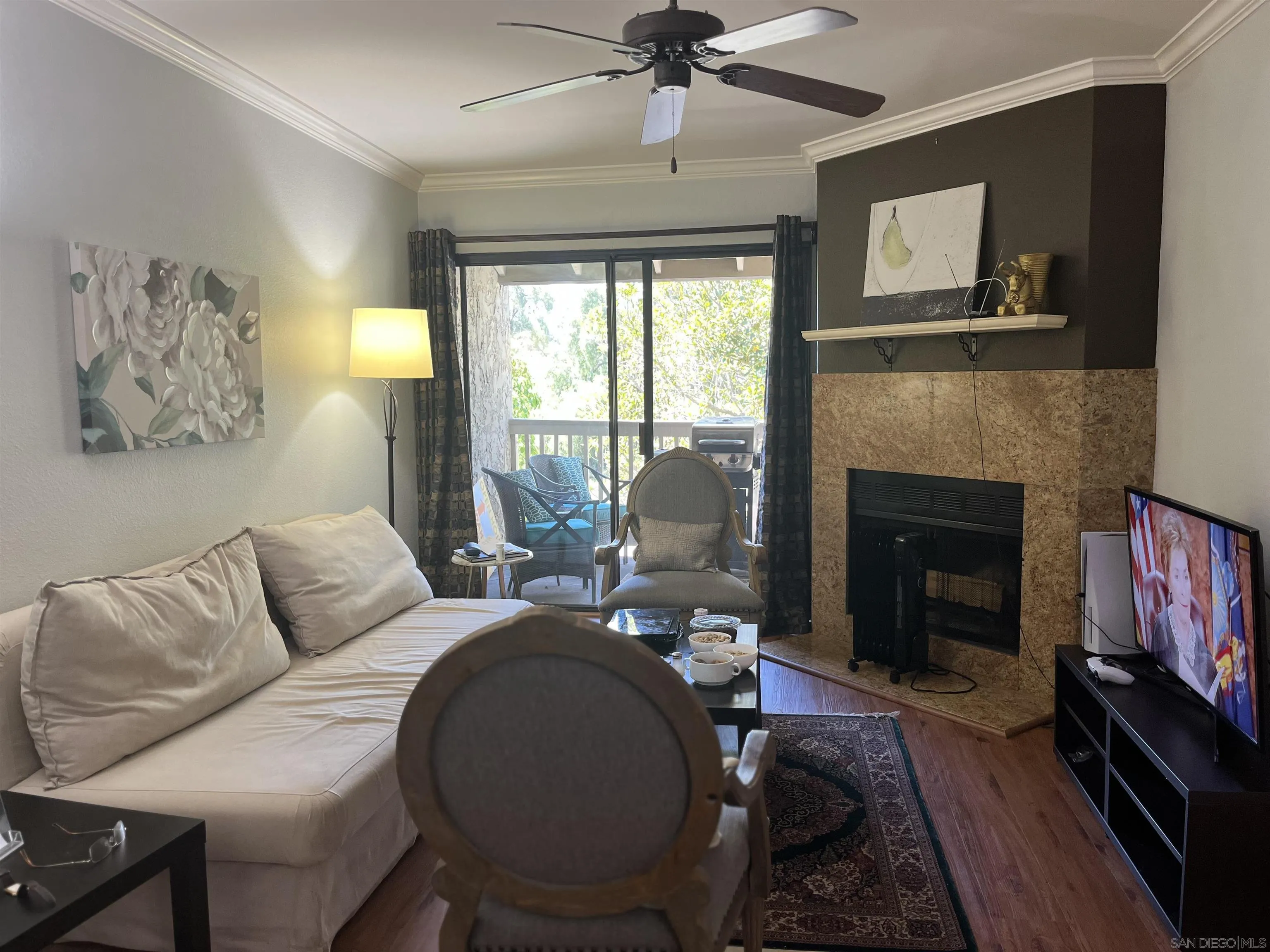 9929 Azuaga Street, Unit F 202 San Diego, CA 92129 - Photo 5 of 18 a living room with furniture a flat screen tv and a fireplace