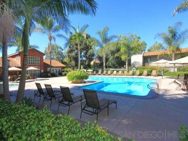 9929 Azuaga Street, Unit F 202 San Diego, CA 92129 - Photo 8 of 18 a view of a swimming pool with lawn chairs under an umbrella