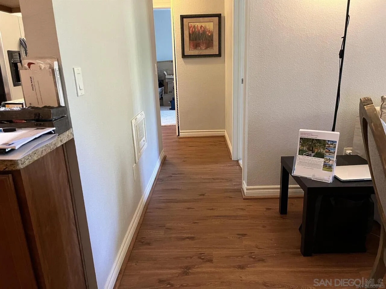 9929 Azuaga Street, Unit F 202 San Diego, CA 92129 - Photo 10 of 18 a view of a hallway with wooden floor and a flat screen tv