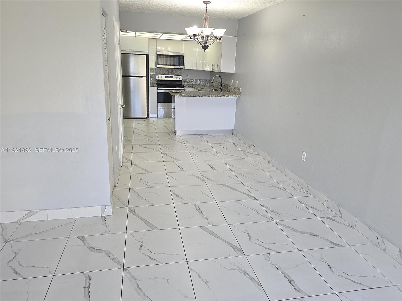 1750 West 56th Street, Unit 216 Hialeah, FL 33012 - Photo 13 of 14 a kitchen with stainless steel appliances granite countertop a sink and cabinets