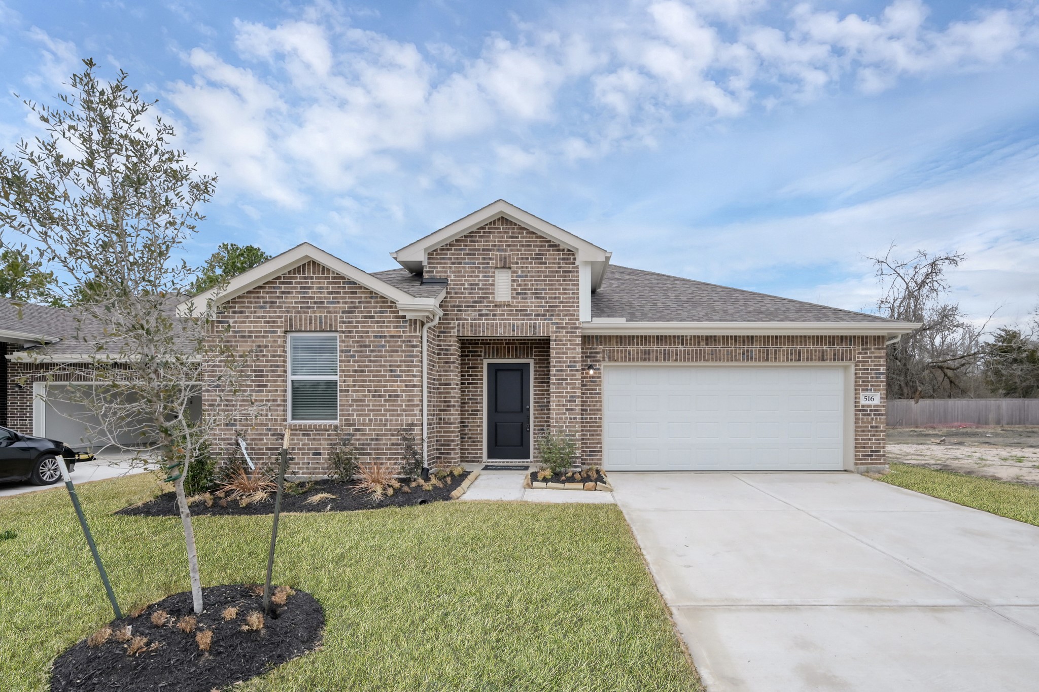 516 Monarch Trail Huntsville, TX 77340 - Photo 2 of 20 a front view of a house with a garden and yard