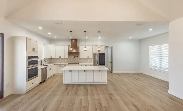 a kitchen with stainless steel appliances a refrigerator sink and stove top oven