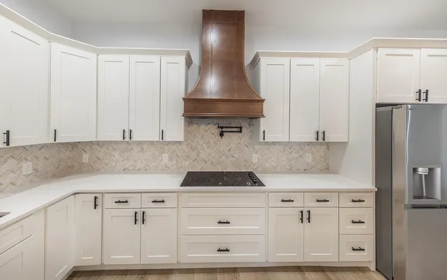 a kitchen with white cabinets and stainless steel appliances