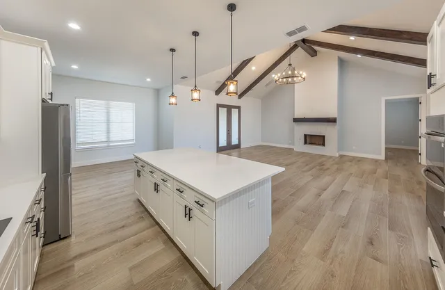a kitchen with a stove and a wooden floor