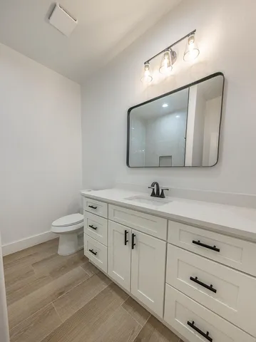 a bathroom with a toilet a sink and mirror