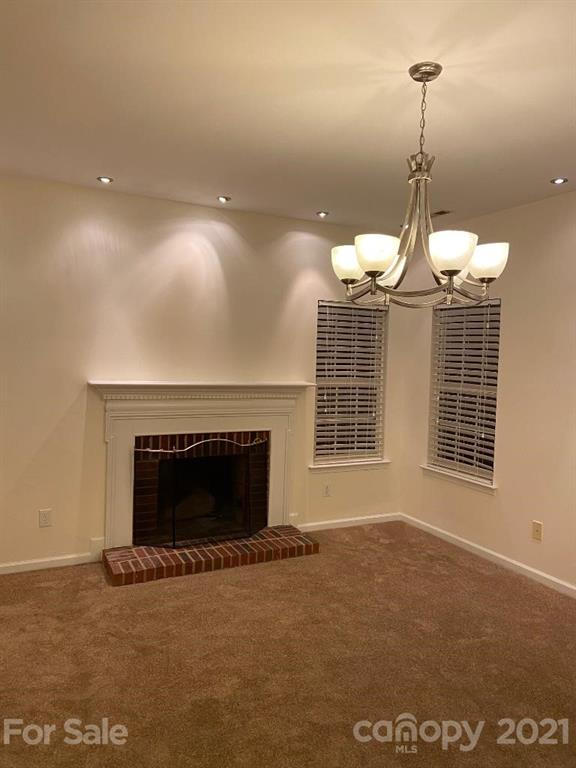 901 Cadogan Court Fort Mill, SC 29708 - Photo 14 of 33 a view of a livingroom with a fireplace wooden floor and a chandelier