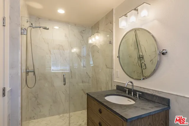 a bathroom with a sink vanity granite and a mirror