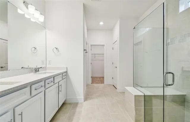 a spacious bathroom with a double vanity sink mirror and shower