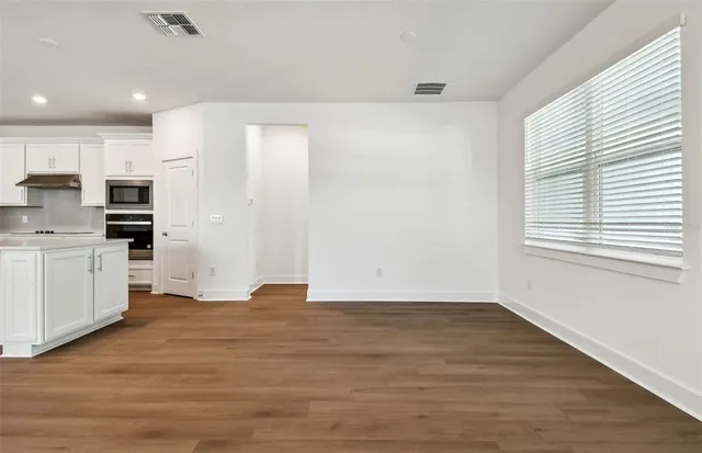 a view of kitchen with wooden floor and electronic appliances