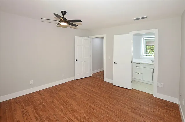 a view of a livingroom with wooden floor and a ceiling fan