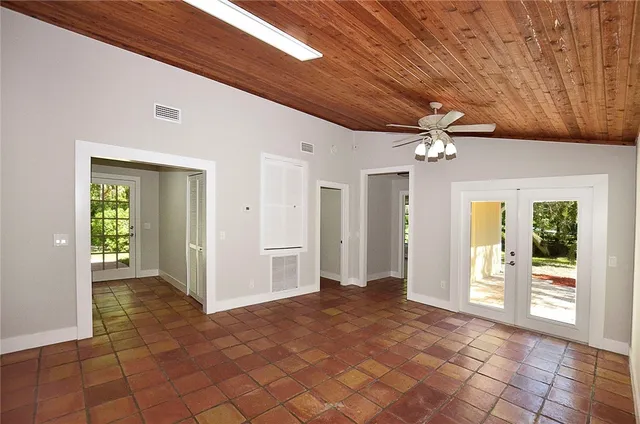 a view of a hallway with wooden floor and chandelier