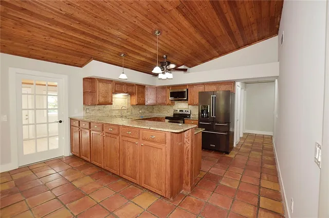 a large kitchen with stainless steel appliances granite countertop a stove a sink dishwasher and a refrigerator