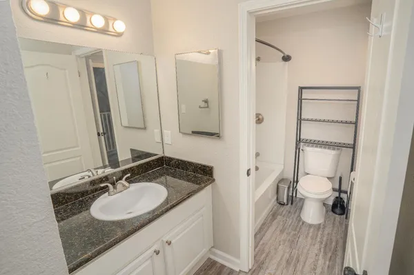 a bathroom with a granite countertop sink and a mirror