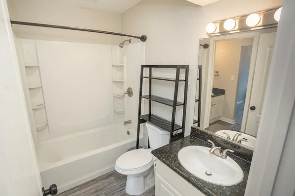 a bathroom with a sink toilet a mirror and shower