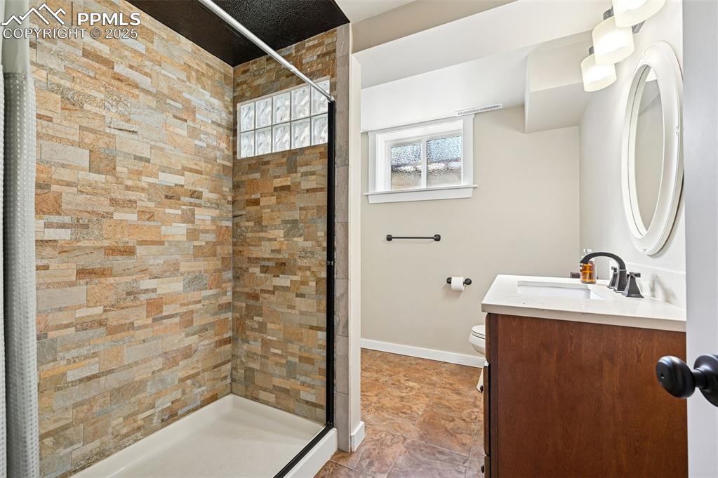 1305 Sunset Road Colorado Springs, CO 80909 - Photo 27 of 50 a bathroom with a sink a toilet and shower