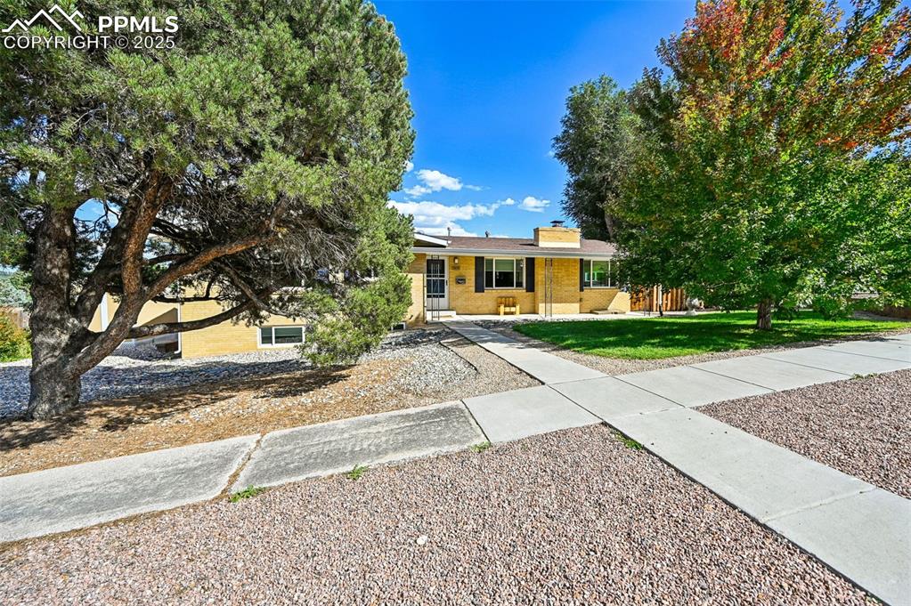 1305 Sunset Road Colorado Springs, CO 80909 - Photo 3 of 50 a front view of a house with a yard and potted plants