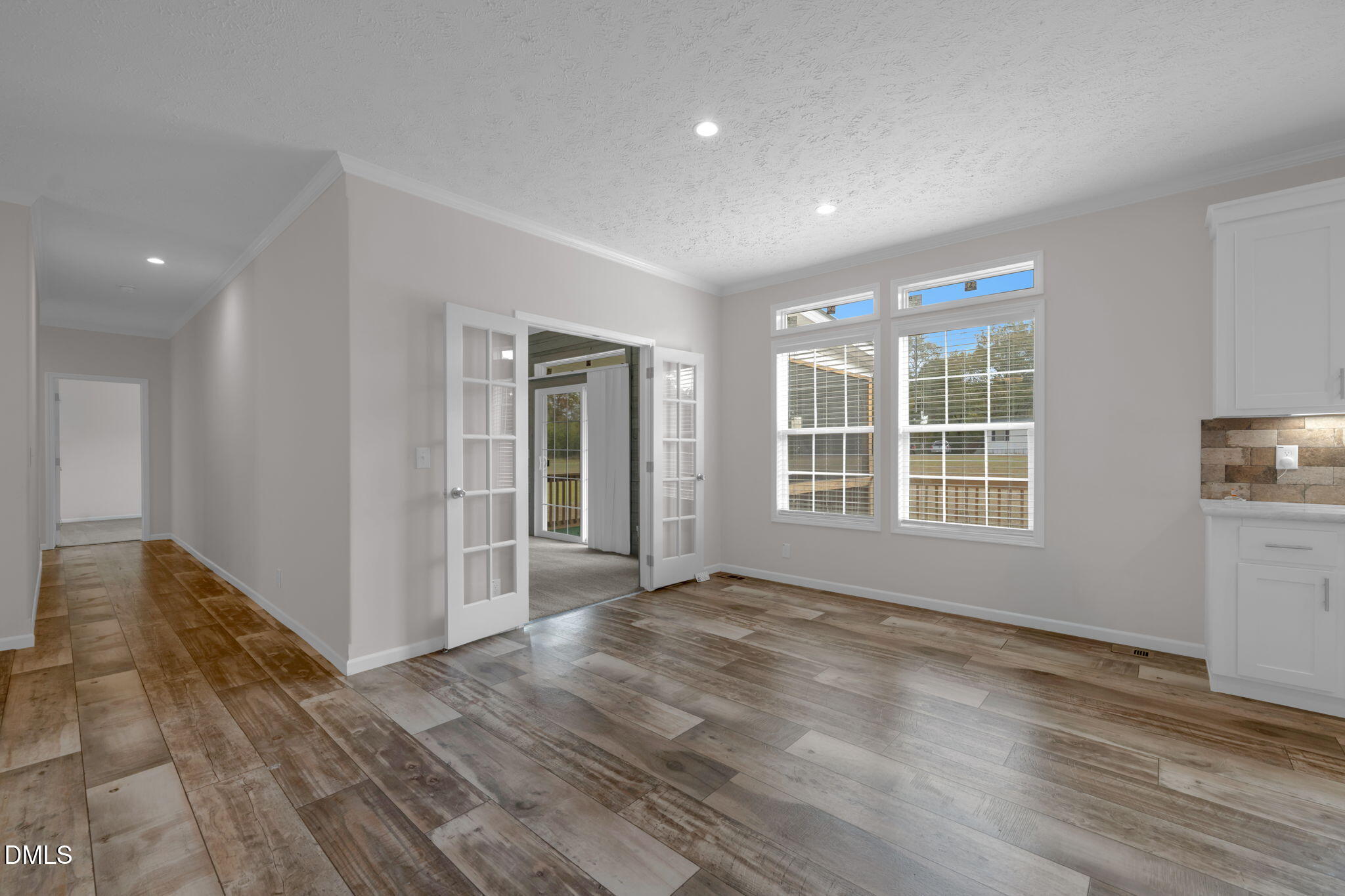 748 Gum Swamp Road Four Oaks, NC 27524 - Photo 7 of 43 a view of an empty room with wooden floor and a window