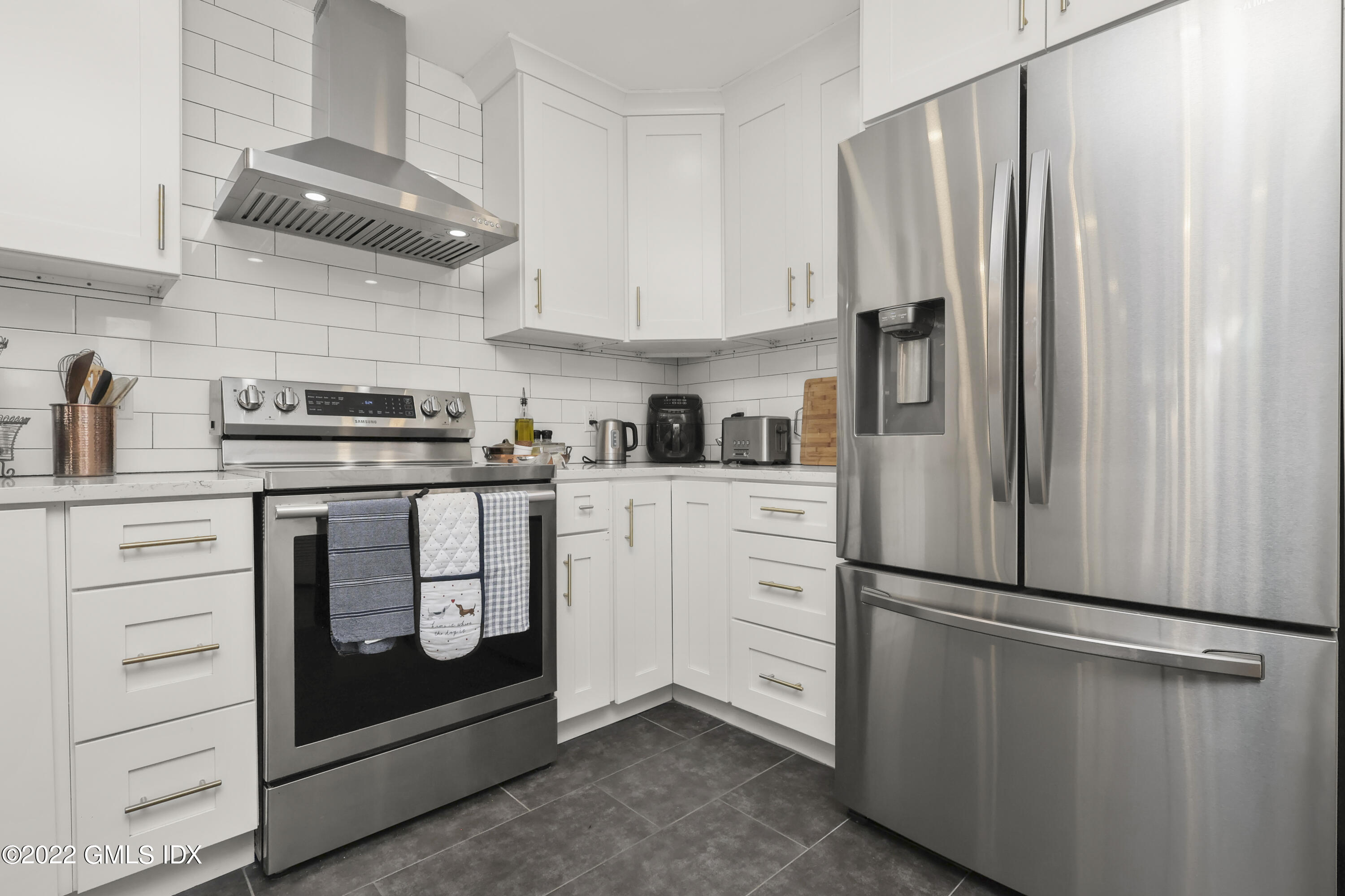 9 River Road, Unit 406 Cos Cob, CT 06807 - Photo 2 of 23 a kitchen with white cabinets and stainless steel appliances