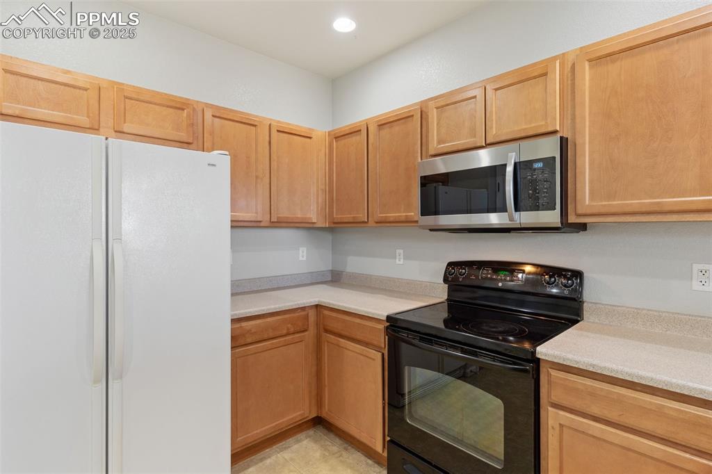 7644 Sandy Springs Point Fountain, CO 80817 - Photo 12 of 27 a kitchen with a microwave a stove and cabinets