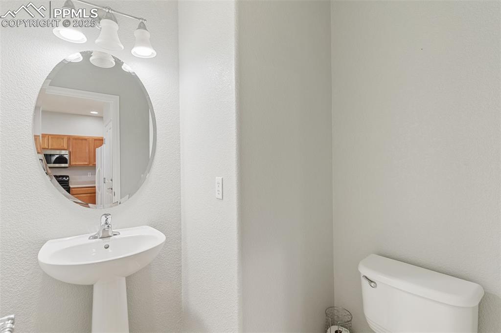 7644 Sandy Springs Point Fountain, CO 80817 - Photo 14 of 27 a bathroom with a toilet a sink and mirror