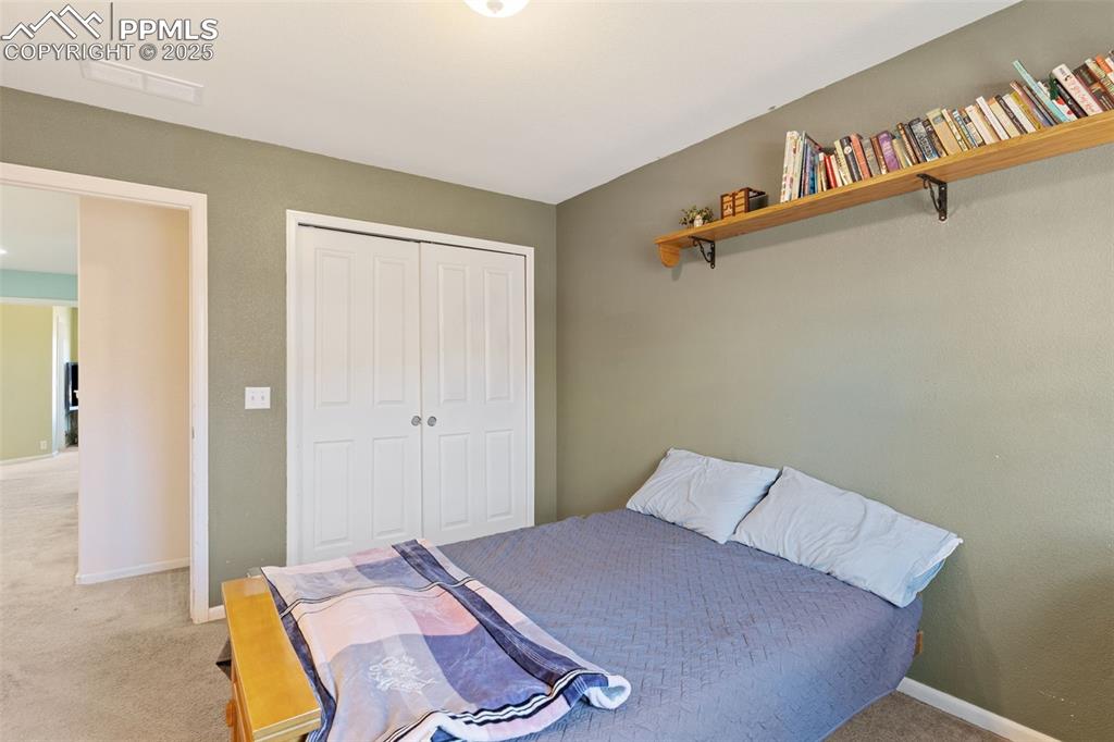 7644 Sandy Springs Point Fountain, CO 80817 - Photo 22 of 27 a bed room with a bed and a book shelf