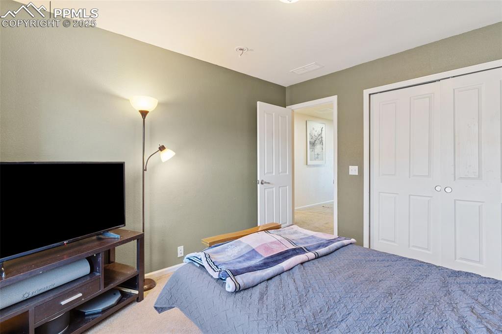 7644 Sandy Springs Point Fountain, CO 80817 - Photo 23 of 27 a bedroom with a bed and a flat screen tv