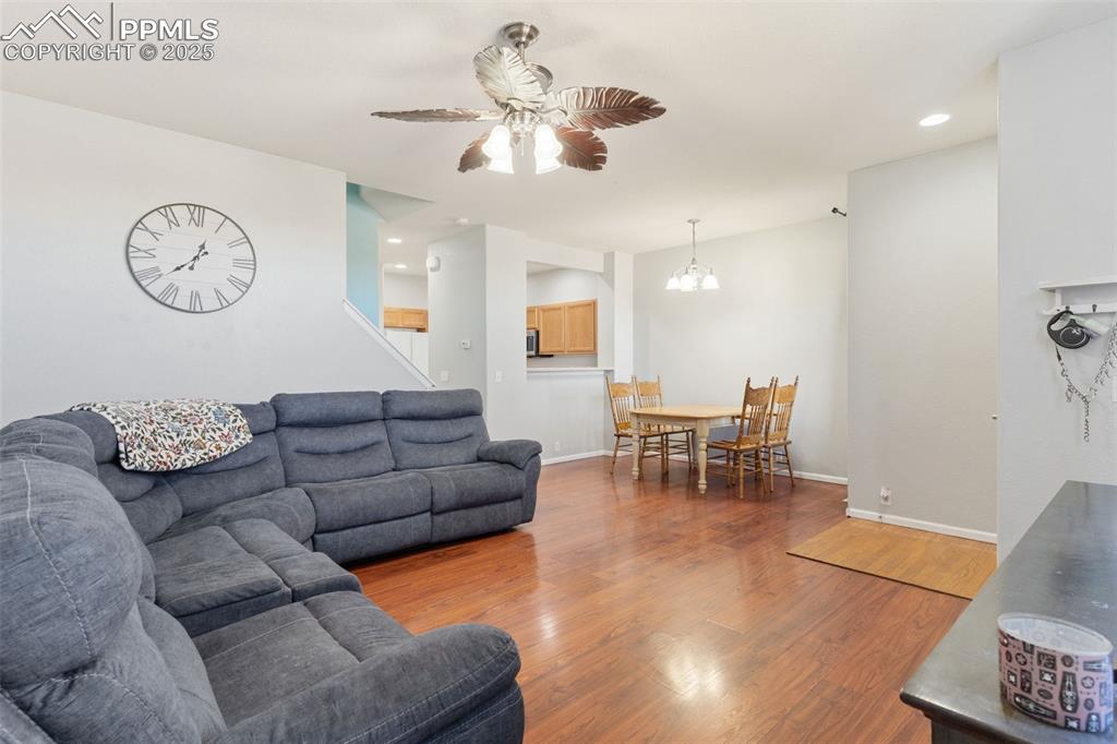 7644 Sandy Springs Point Fountain, CO 80817 - Photo 7 of 27 a living room with furniture a wooden floor and a chandelier