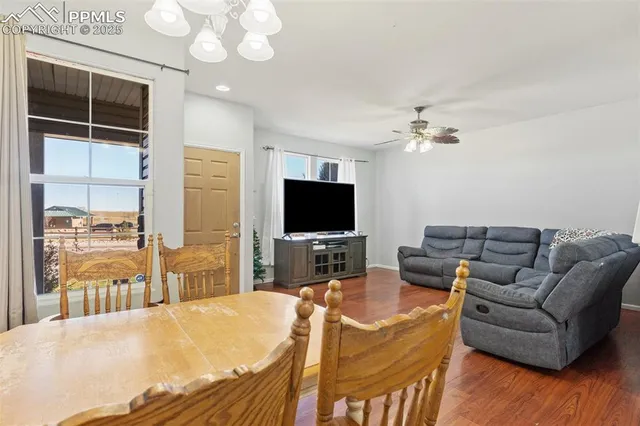 a living room with furniture a flat screen tv and kitchen view