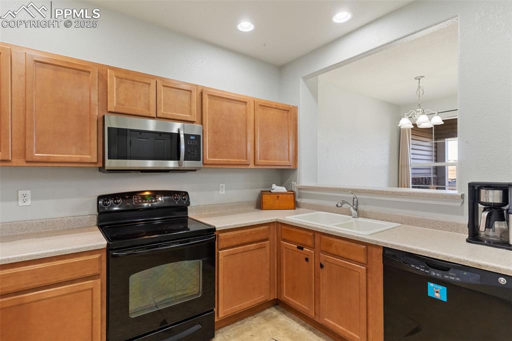 7644 Sandy Springs Point Fountain, CO 80817 - Photo 10 of 27 a kitchen with a sink stove and microwave