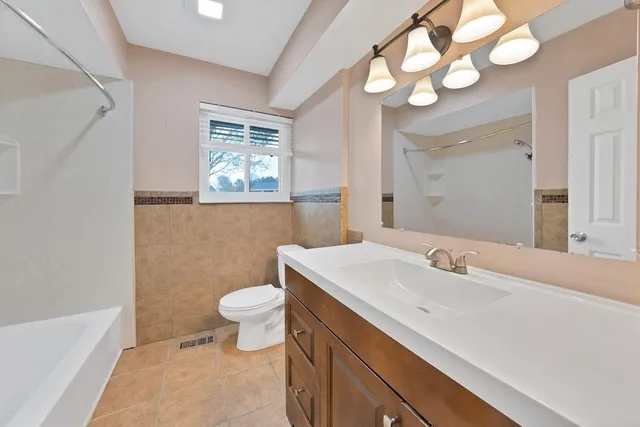 a bathroom with a sink a toilet and a mirror