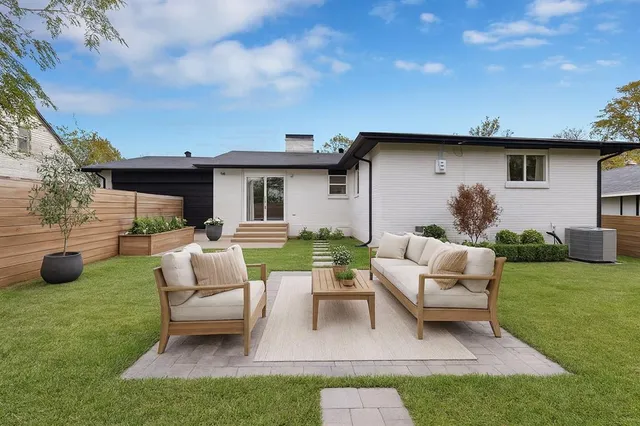 a view of backyard of a house with seating space