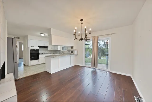 a view of kitchen with granite countertop cabinets and refrigerator
