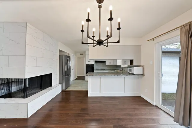 a kitchen with stainless steel appliances kitchen island a fireplace and wooden floor