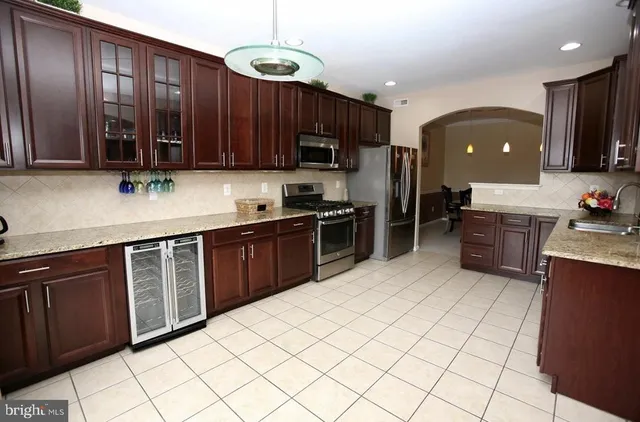 a kitchen with stainless steel appliances granite countertop a stove top oven a sink dishwasher and a microwave oven on the blue kitchen countertops