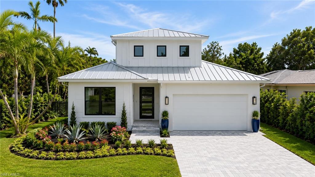 3028 Woodside Avenue Naples, FL 34112 - Photo 1 of 13 a front view of a house with garden