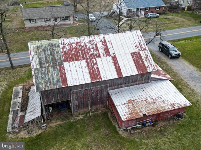 a aerial view of a house next to a big yard with plants and large trees