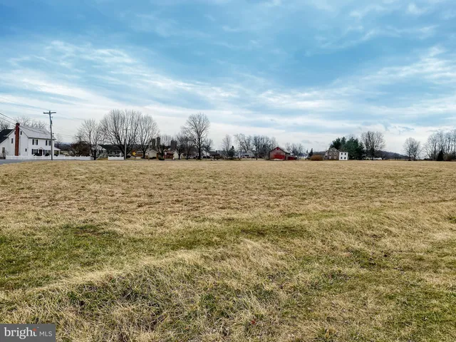 a view of a house with a big yard and large trees