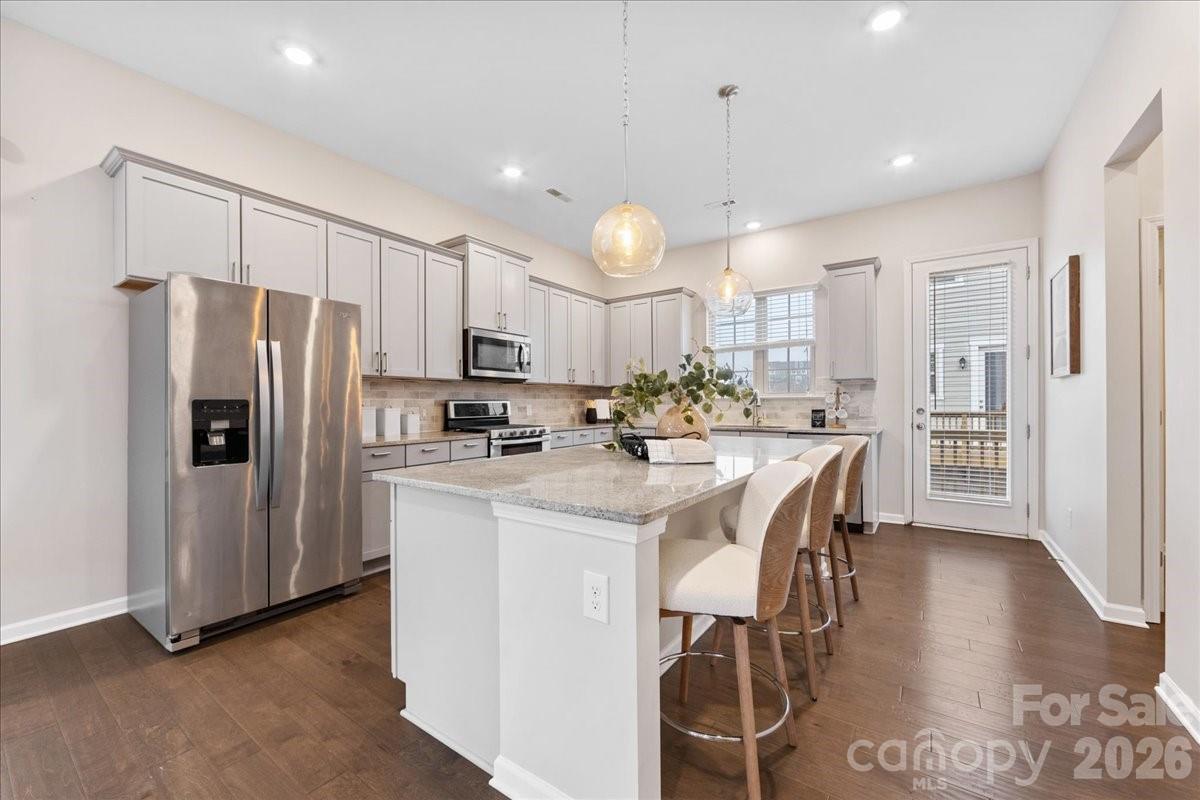 9205 Bluefield Street Charlotte, NC 28273 - Photo 15 of 48 a kitchen with stainless steel appliances a refrigerator a stove a sink a dining table and chairs