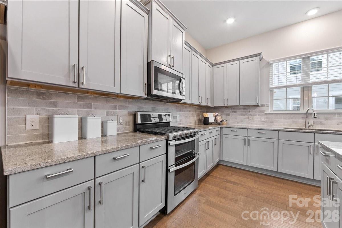 9205 Bluefield Street Charlotte, NC 28273 - Photo 16 of 48 a kitchen with stainless steel appliances granite countertop a sink a stove and cabinets