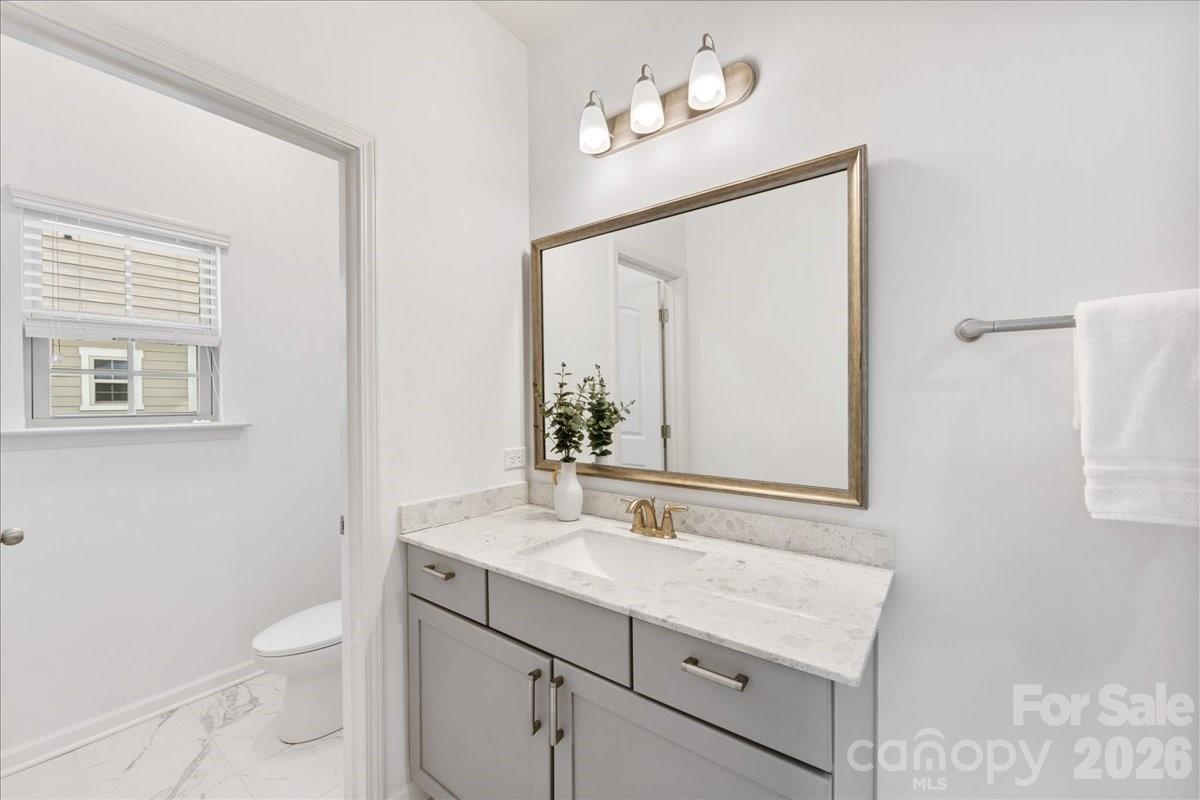 9205 Bluefield Street Charlotte, NC 28273 - Photo 36 of 48 a bathroom with a toilet a sink a mirror and a window