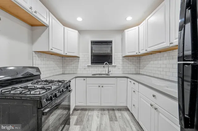 a kitchen with granite countertop a sink stove and cabinets