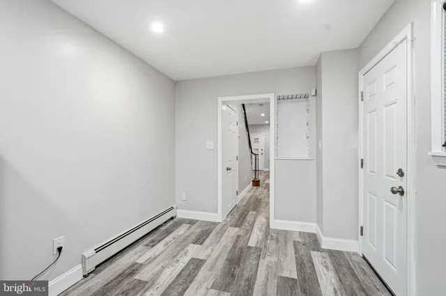 a view of a hallway with wooden floor and staircase