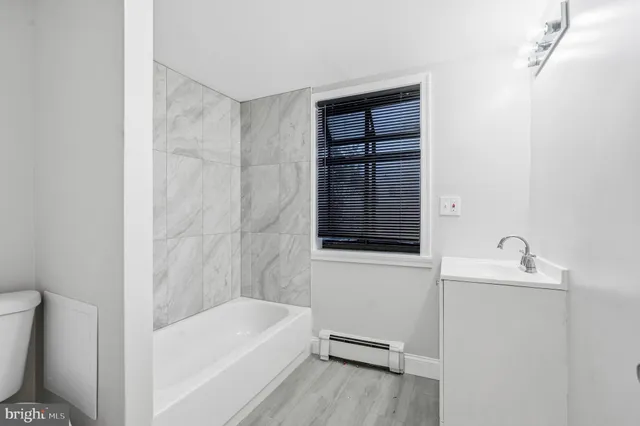 a bath tub sitting next to a white toilet and sink