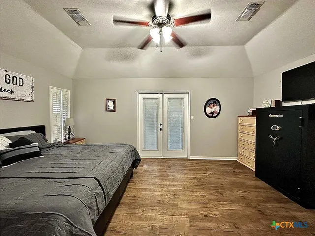 a bedroom with a bed and a flat tv screen on dresser