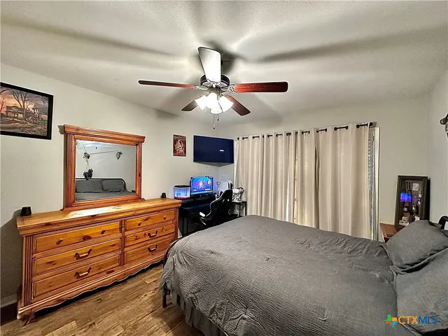a bedroom with a bed and a dresser with a flat tv screen