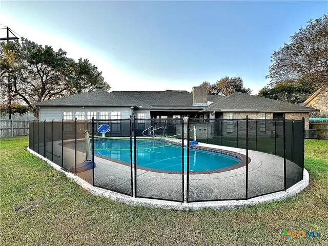 a view of a house with a swimming pool and a yard