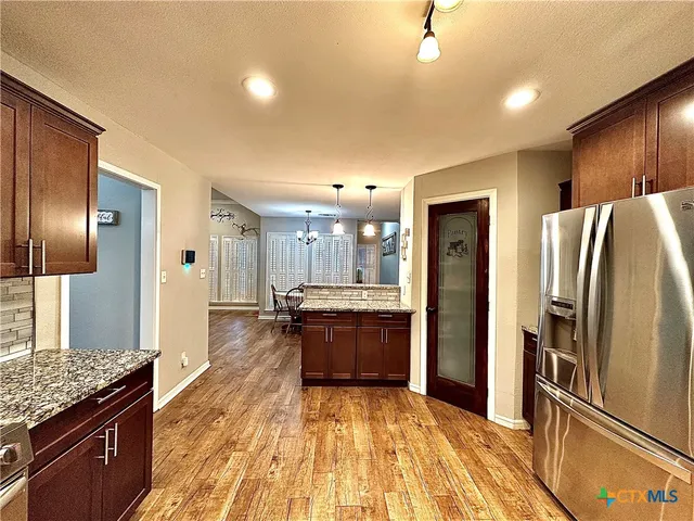 a kitchen with stainless steel appliances kitchen island granite countertop a refrigerator and stove