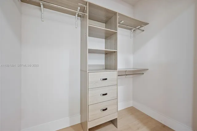 a view of walk in closet with empty racks