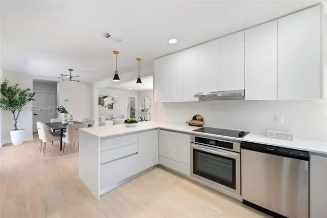 a kitchen with a white cabinets and stove top oven